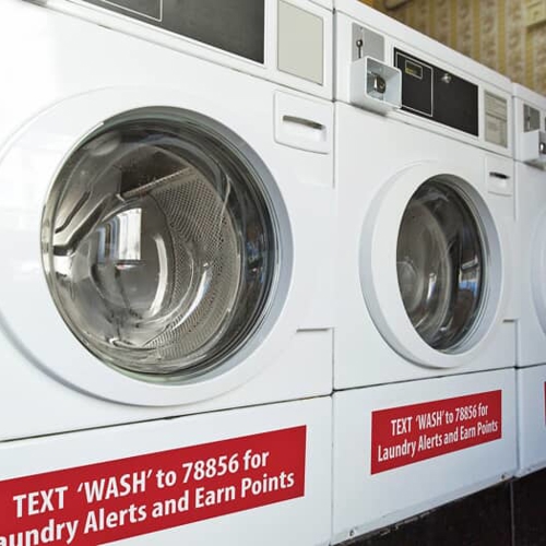 red decal sign with white text on washing machine