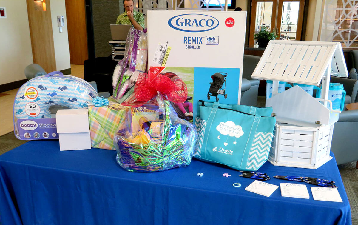 table of promotional items including a branded tote bag and pens